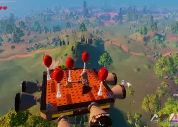 Captura de pantalla de Lego Fortnite mostrando una estructura flotante de ladrillos Lego con globos rojos sobre un paisaje virtual verde con árboles y lagos, bajo un cielo azul claro.