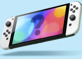 The image shows a Nintendo Switch gaming console against a plain light blue background. The screen of the Switch displays a colorful, abstract design with a large question mark in the center, suggesting a sense of mystery or an announcement about an upcoming game or feature. The Joy-Con controllers are attached to either side of the device, indicating it is in handheld mode.