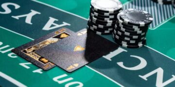 Uma mão de cartas de blackjack revelando um Ás de espadas, acompanhada por fichas de cassino empilhadas sobre o feltro verde da mesa de jogo