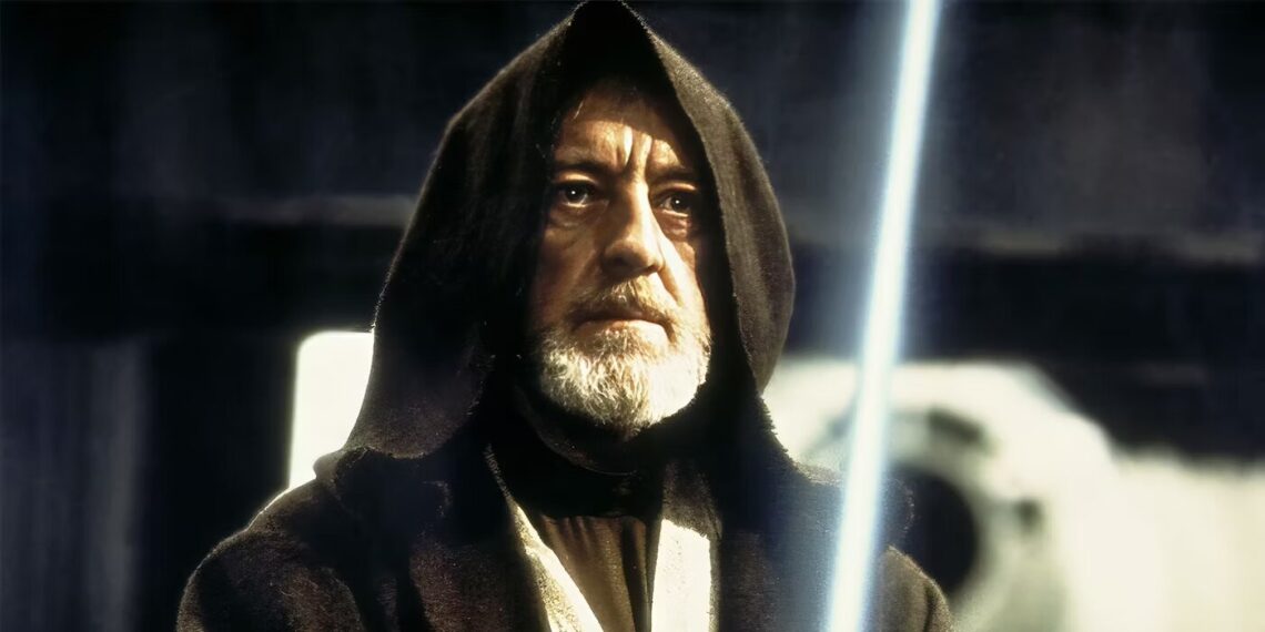 Alec Guinness como Obi-Wan Kenobi en 'Star Wars: Episodio IV', con capucha y sable de luz encendido, reflejando sabiduría y una profunda seriedad en su mirada