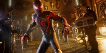 A scene from the Spider-Man 2 game shows Miles Morales in his black and red Spider-Man suit, surrounded by enemies with high-tech gear in a dimly lit room.