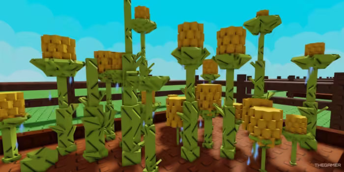 A garden bed in Roblox's Grow a Garden game filled with tall, blocky pineapple plants. Each plant has a green stem with yellow, cubed pineapple fruit on top. Water droplets appear around the plants, indicating they are being watered. A wooden fence surrounds the garden, and a bright blue sky with clouds is in the background.