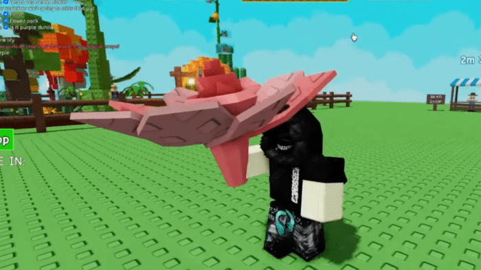 Roblox avatar holds a large pink lily flower in a garden area from the game "Grow a Garden"; colorful trees and shop signs in the background.